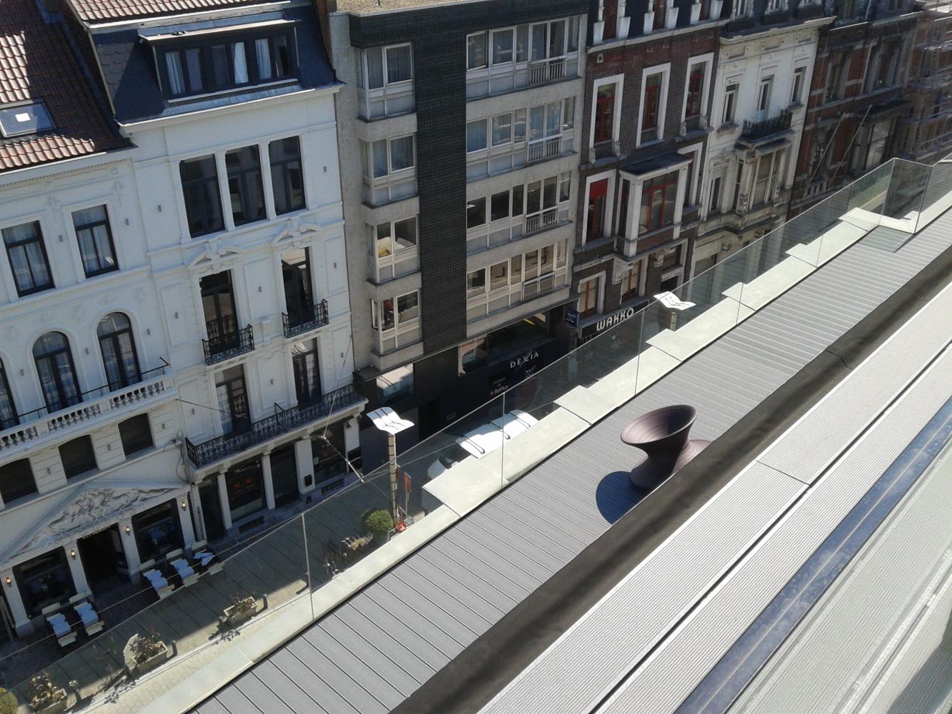 Realisatie in glaswerk: verbouwing van kantoren en lofts in centrum Gent – glazen borstwering rond dakterras met puttinggreen.